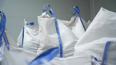 Depo, pencere pervazlarının yapımında kullanılan çeşitli kuru erzaklarla dolu büyük çantalar içeriyor. Döngü saplı büyük poşetlerde geri dönüşümlü plastik malzemeler.