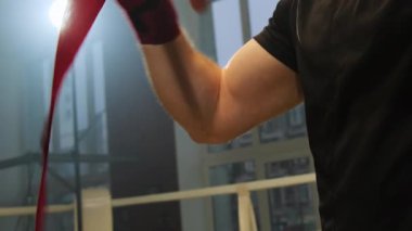 Boksör antrenmandan önce ellerini özel bandajlara sarar. Erkek sporcu gerçek dövüşte eklemleri korumak ve tendonları desteklemek için elastik kumaş kullanır