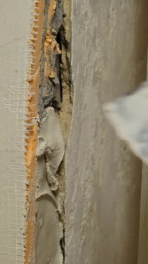 Sıvacı duvardaki deliğe taze sıva bastırıyor. Tamirci dokuyu arıtmak için alçı katmanı uygular ve duvarı pürüzsüz bir görünüm verir.