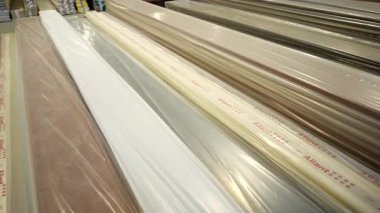 KYIV, UKRAINE - 15 Mart 2024: Üst üste dizilmiş metalden yapılmış uzatılmış ince paneller. Malzemeler şeffaf plastik kaplamalı. Bu da depolama ve sevkiyata hazırlık demektir.