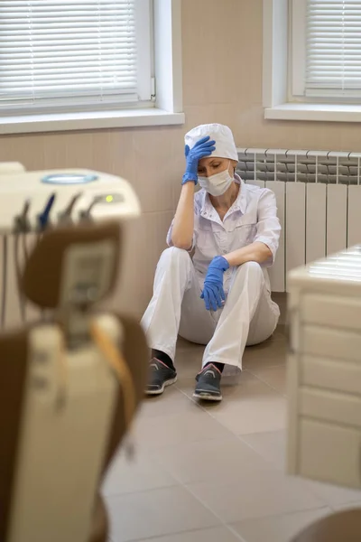 Μια Κουρασμένη Γιατρός Κάθεται Στο Πάτωμα Του Γραφείου Της Μετά — Φωτογραφία Αρχείου