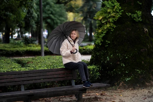 Kvinna Med Paraply Sitter Parkbänk Regnigt Väder — Stockfoto
