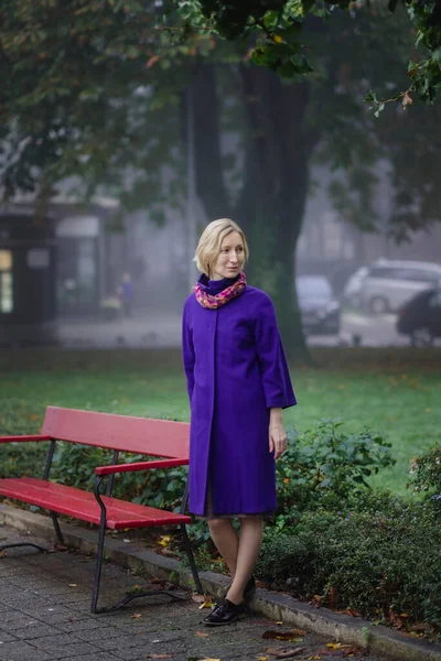Woman Lilac Coat Stands Park Bench — Stock Photo, Image