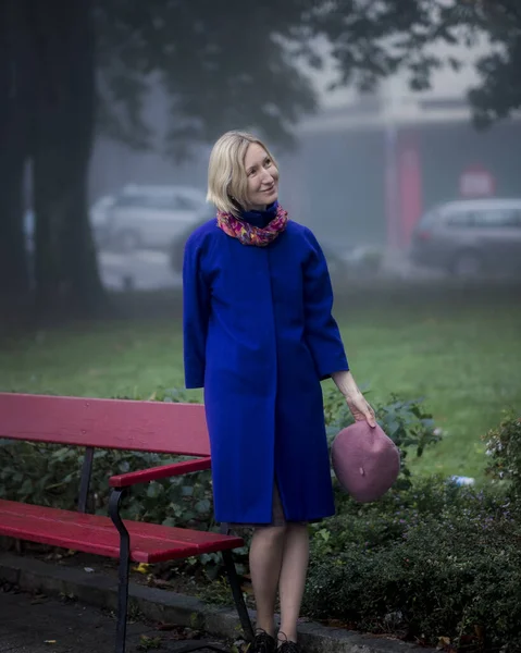 Eine Frau Blauen Mantel Steht Neben Einer Parkbank — Stockfoto