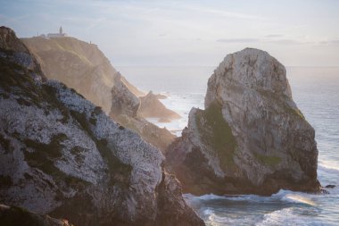 Güneş batarken Cape Roca 'nın kayalıklarını ve okyanus sörfünü görmek. Sintra, Portekiz. 