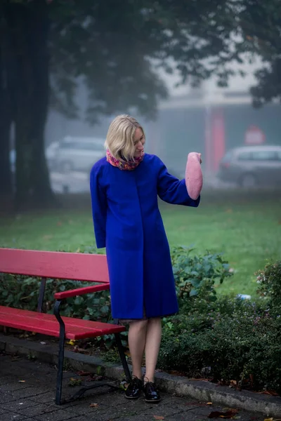Kvinnan Står Vid Parkbänk Och Håller Basker Handen — Stockfoto