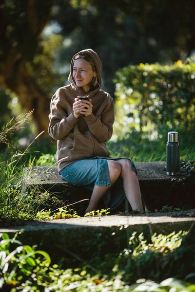 공원에 여자는 음료를 마시는 즐겼다 — 스톡 사진