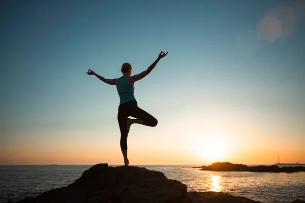 日落时在海滩上做瑜伽的女人 — 图库照片