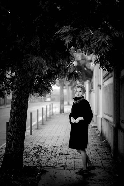 一个穿着外套和贝雷帽的女人在城市街道上 黑白照片 — 图库照片