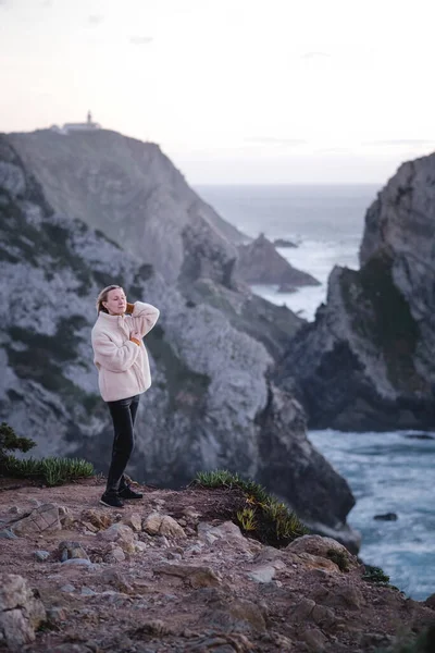 A woman stands on the Atlantic cliffs near Cape Roca, Sintra, Portugal.