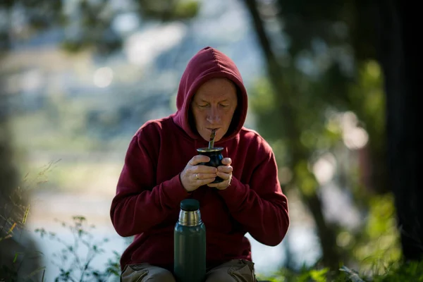 A man drinks mate by a Mate cup in the Park.
