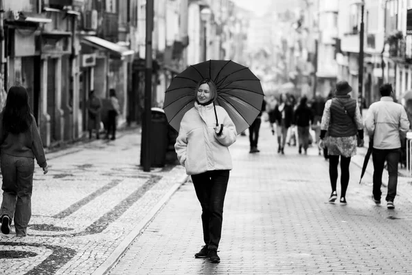 ポルトガルのポルトにあるサンタカタリーナ大通りに傘を差した女性 白黒写真 — ストック写真