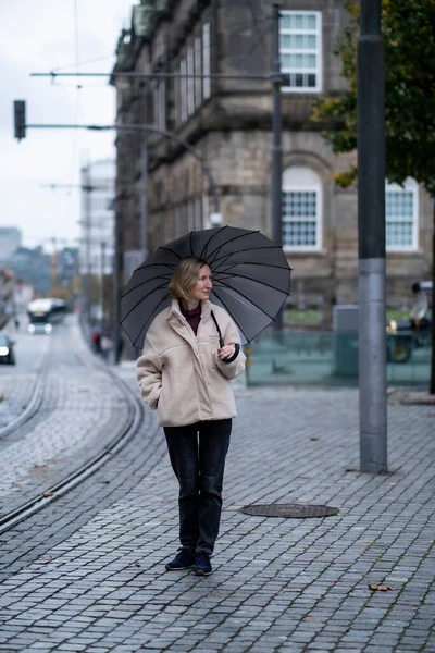 stock image A woman with an umbrella on the street, Porto, Portugal.