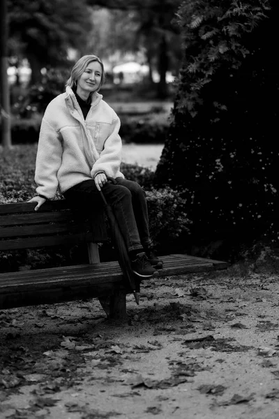 Μια Γυναίκα Κάθεται Ένα Παγκάκι Ένα Φθινοπωρινό Πάρκο Ασπρόμαυρη Φωτογραφία — Φωτογραφία Αρχείου