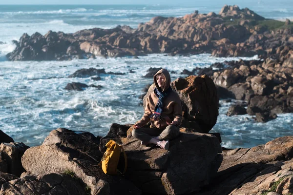Okyanus Kıyısındaki Kayalarda Bir Kadın Gezgin Oturuyor — Stok fotoğraf