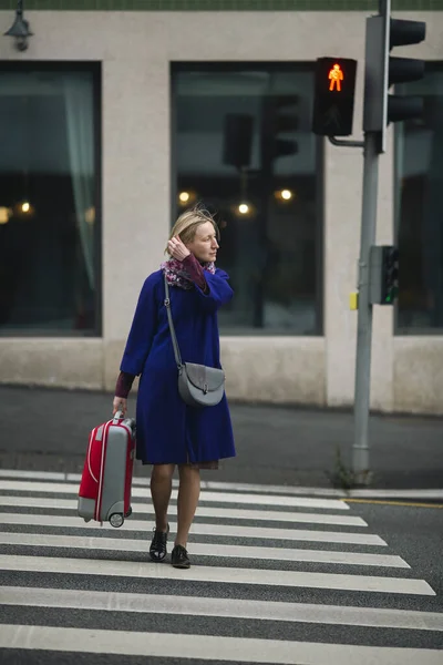 横断歩道を歩くスーツケースを持った女性 — ストック写真