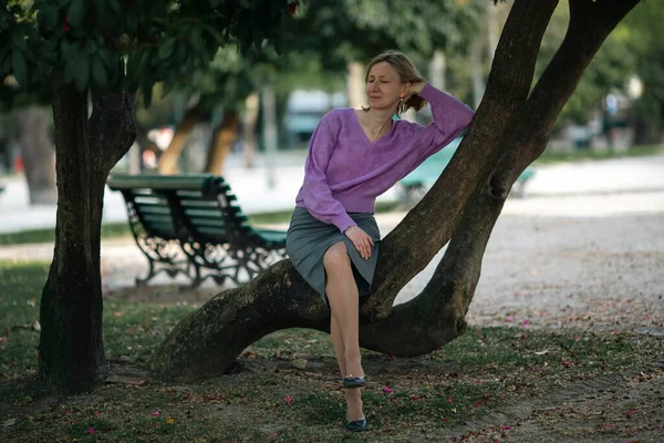 Uma Mulher Senta Nas Raízes Uma Árvore Parque — Fotografia de Stock