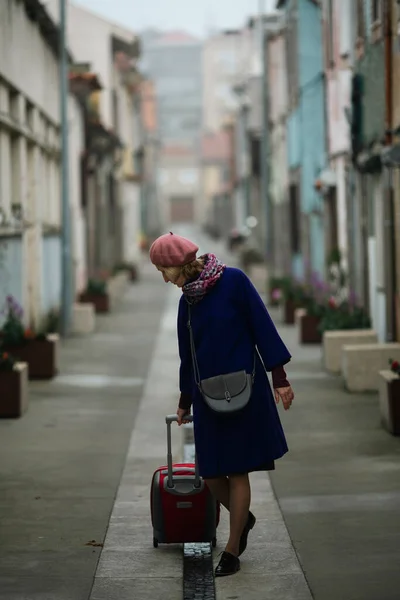Eine Frau Rollt Einen Koffer Die Straße Hinunter — Stockfoto