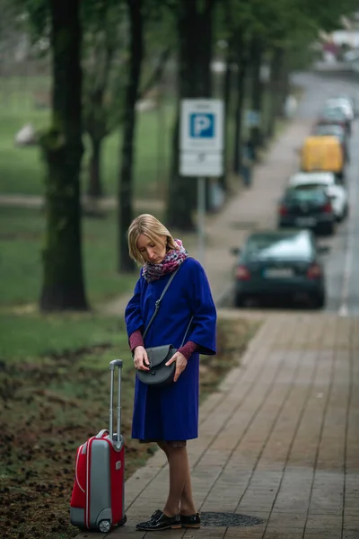 Eine Frau Mit Rotem Koffer Steht Auf Dem Bürgersteig Und — Stockfoto