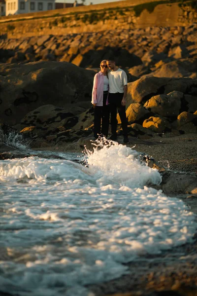 一对年轻夫妇正在观看海滨冲浪 — 图库照片