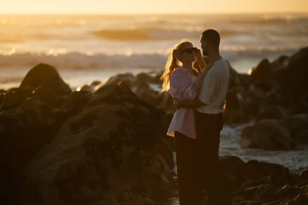 在金色的落日下 年轻夫妇坠入爱河 拥抱着大海 — 图库照片