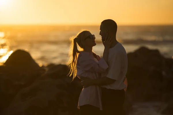 一对浪漫的年轻夫妇在美丽的落日下在海边约会 — 图库照片