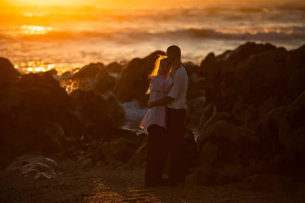 Gün Batımında Kayalık Bir Sahilde Birbirine Aşık Genç Bir Çift — Stok fotoğraf