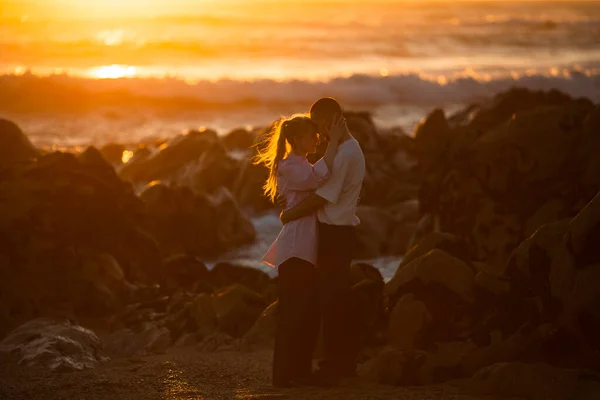 一对年轻夫妇在一次浪漫的约会中坠入爱河 那是在美丽的落日下 在海洋的岩石海岸上 — 图库照片