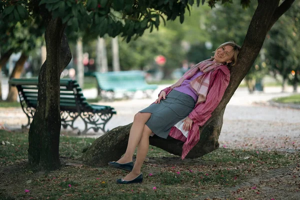 Una Mujer Descansa Sobre Las Raíces Árbol Parque Imagen de archivo