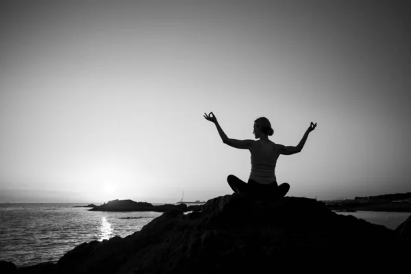 日没時に海に蓮の花のポーズをした女性のヨガのシルエット 白黒写真 — ストック写真