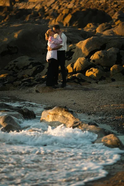 Gün Batımında Okyanus Kıyısında Öpüşen Genç Bir Çift — Stok fotoğraf