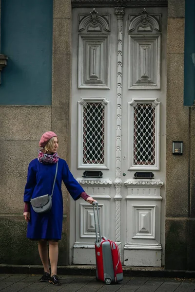 Een Vrouw Met Een Koffer Aan Voordeur Van Een Traditioneel Rechtenvrije Stockafbeeldingen