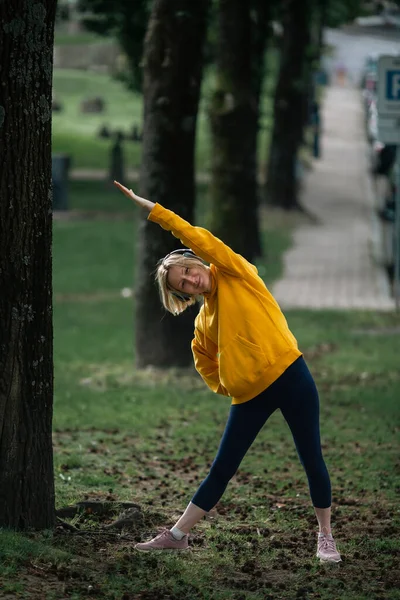 公園でヘッドフォンの練習をしている女性 — ストック写真
