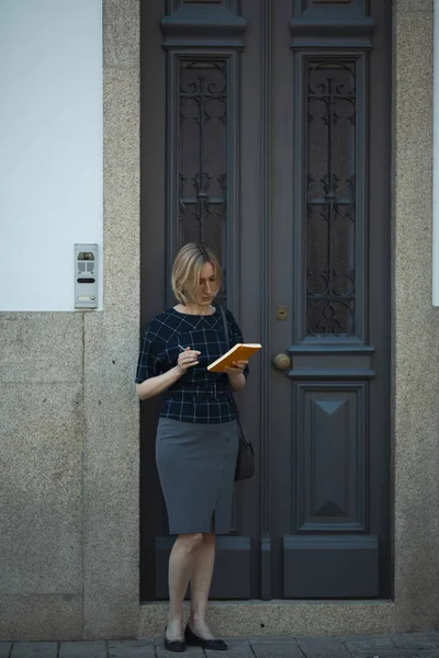Μια Γυναίκα Σημειωματάριο Στέκεται Έξω Από Την Παραδοσιακή Πόρτα Ενός — Φωτογραφία Αρχείου