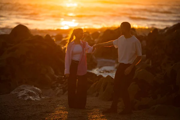 Een Jong Stel Het Strand Tijdens Een Gouden Zonsondergang — Stockfoto