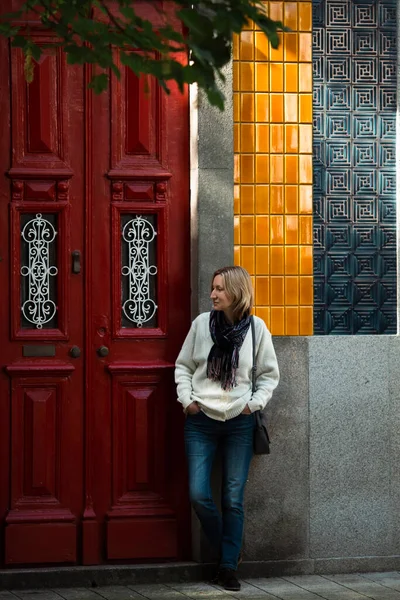 ポルトガルの伝統的な家の壁で女性が待っています — ストック写真