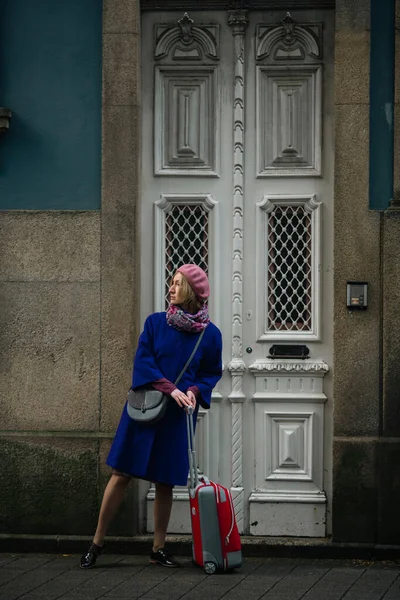 Μια Γυναίκα Βαλίτσα Στέκεται Στην Πόρτα Ενός Παραδοσιακού Σπιτιού Στο — Φωτογραφία Αρχείου