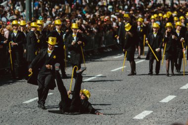 PORTO, PORTUGAL - 9 Mayıs 2023: Porto 'nun Queima das Fitas Geçidi - Portekizli üniversite öğrencilerinin yıllık şenliği. Mezunlar bir silindir şapka ve baston takıyorlar. İkisi de fakültenin renginde..