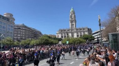 PORTO, PORTUGAL - 9 Mayıs 2023: Porto 'nun Queima das Fitas Geçidi - Portekizli üniversite öğrencilerinin yıllık şenliği. Mezunlar bir silindir şapka ve baston takıyorlar. İkisi de fakültenin renginde.. 