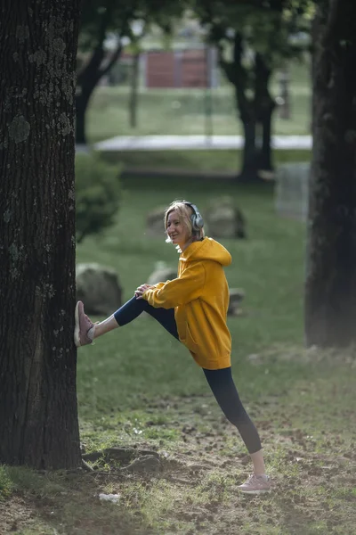 Kulaklık Takan Bir Kadın Parkta Egzersiz Yapıyor — Stok fotoğraf