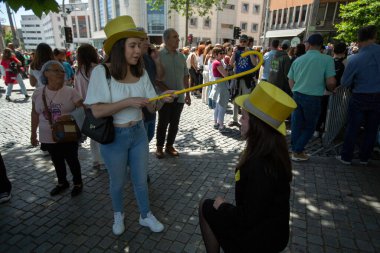 PORTO, PORTUGAL - 9 Mayıs 2023: Porto 'nun Queima das Fitas Geçidi - Portekizli üniversite öğrencilerinin yıllık şenliği. Mezunlar bir silindir şapka ve baston takıyorlar. İkisi de fakültenin renginde..