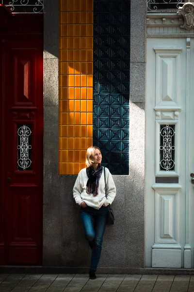 ポルトガルの伝統的なタウンハウスの外に立っている間 女性は日光を楽しんでいます — ストック写真