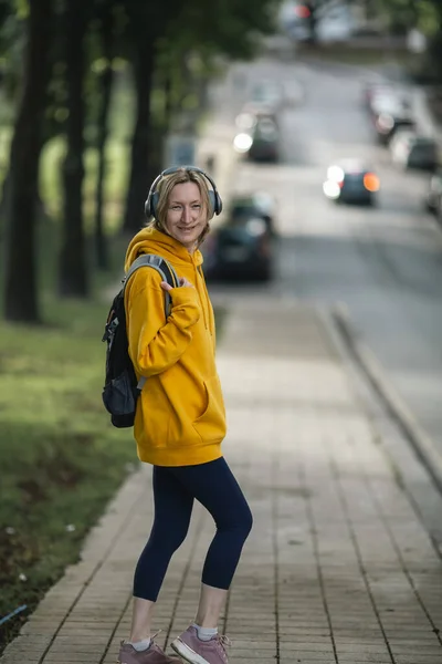 Eine Frau Mit Kopfhörern Steht Auf Der Straße — Stockfoto