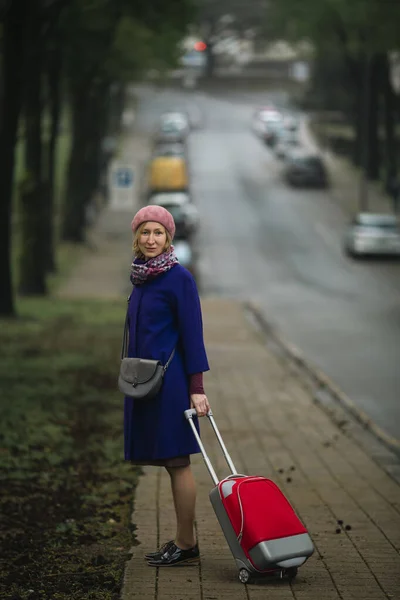 Μια Γυναίκα Κόκκινη Βαλίτσα Περπατάει Στο Δρόμο — Φωτογραφία Αρχείου
