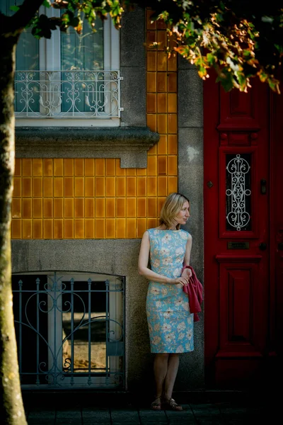 ポルトガルのポルトにある伝統的なタウンハウスのドアの近くに女性が立っています — ストック写真