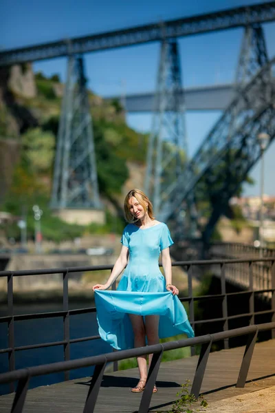 一个穿着蓝色衣服的女人站在城市的人行道上 — 图库照片