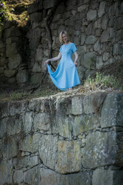 一个穿着蓝色衣服的女人在一个古老的废墟中摆姿势 — 图库照片
