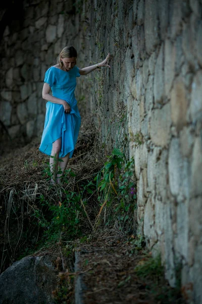 青い服を着た女性が古代の遺跡を通って彼女の道を作る — ストック写真