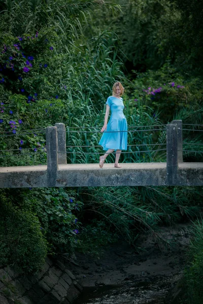 Μια Γυναίκα Μπλε Φόρεμα Στέκεται Μια Αρχαία Κρεμαστή Γέφυρα — Φωτογραφία Αρχείου