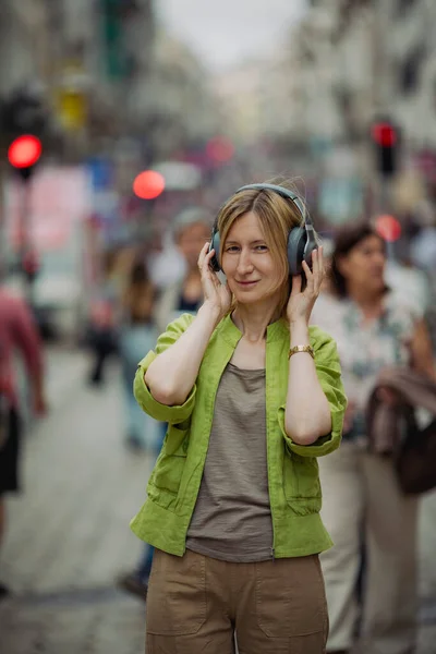 混雑した通りのヘッドフォンを着ている女性 — ストック写真